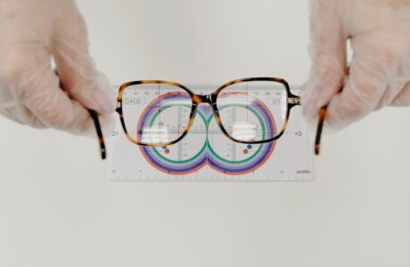 A person putting glasses in front of a measuring paper