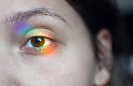 Photo focused on a woman's left eye with a colorful reflection on top of it